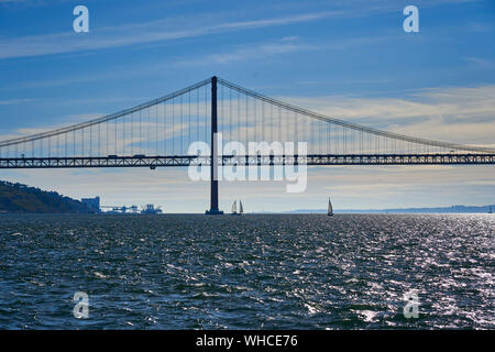 Voile sur le Tage avec Ponte 25 de Abril en arrière-plan de Lisbonne, Portugal. Banque D'Images
