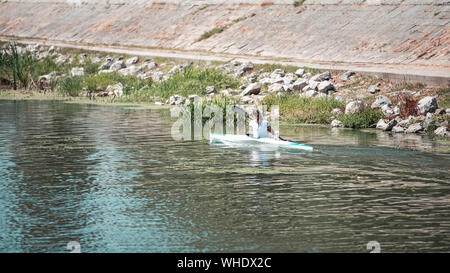 Jeune femme kayak sur le lac, elle est en compétition à l'aviron Banque D'Images