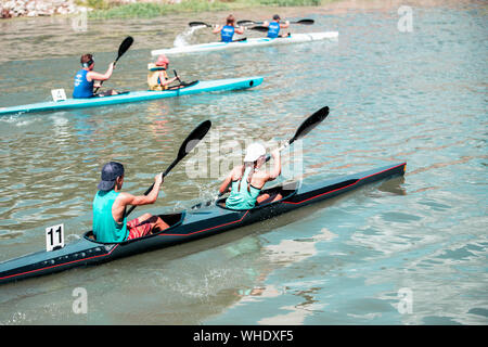 Équipe d'un jeune homme et femme sur l'athlète rowing kayak sur le lac pendant la compétition Banque D'Images