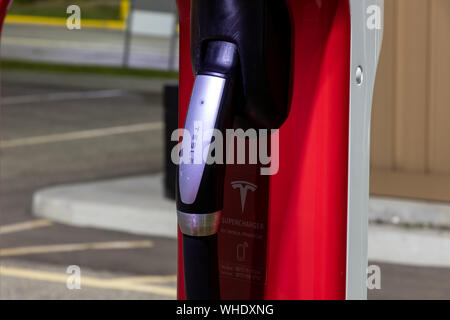 Cordon de charge Tesla à la station de recharge Tesla Supercharger. Banque D'Images