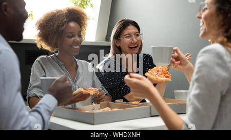Friendly joyeuse équipe multiculturelle s'amusant eating pizza together Banque D'Images