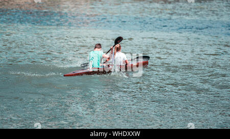 Équipe d'un jeune homme et femme sur l'athlète rowing kayak sur le lac pendant la compétition Banque D'Images