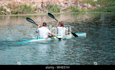 Équipe d'un jeune homme et femme sur l'athlète rowing kayak sur le lac pendant la compétition Banque D'Images