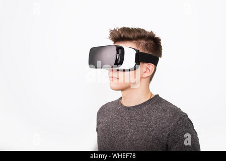 Jeune homme à lunettes viar. Un adolescent joue avec des lunettes de réalité virtuelle. Banque D'Images