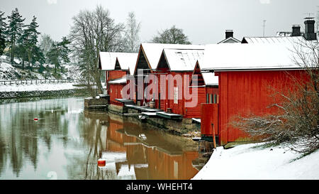 Vieux Porvoo, Finlande historique. Couleur rouge vintage granges Maisons de stockage sur la rivière avec la neige en hiver. Banque D'Images
