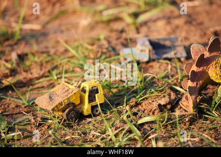 Gros plan d'un jouet jaune sur le sol à proximité herbe avec un arrière-plan flou pendant la journée Banque D'Images