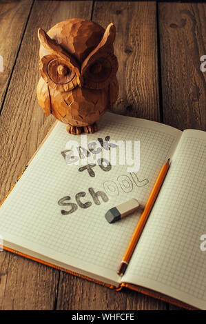 Retour à l'école, la notion de parent. Owl sur une table en bois. L'inscription sur la craie de couleur ardoise. Fournitures scolaires, rustique. Banque D'Images