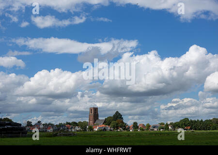 Petit village de Ransdorp près d'Amsterdam s'élevant du champs de pâturage vert agraire avec des nuages dans le ciel bleu au-dessus Banque D'Images