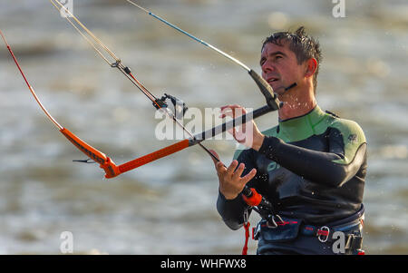 L'homme le kitesurf dans la mer à Llanelli, Carmarthenshire, Pays de Galles. UK. Banque D'Images