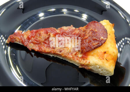 Coupe pizza sur une plaque noire. Pizza slice sur une plaque noire. Banque D'Images