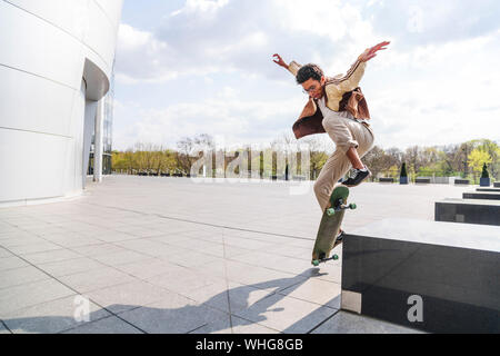 La planche avec les mains en l'air passe dans les escaliers avec skateboard Banque D'Images