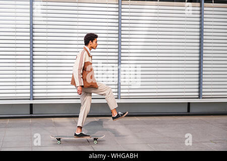 L'homme afro-américain se tient sur roulettes sur une jambe Banque D'Images