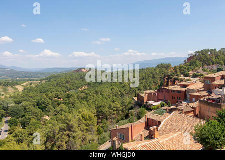 Vue sur Roussillon village sur les collines, les petites Provensal ville avec de grands dépôts d'ocre, situé à l'intérieur de frontières de Parc Naturel Régional du Luberon Banque D'Images