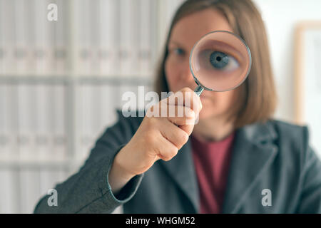 Businesswoman with magnifying glass font des affaires d'audit financier, l'examen et l'évaluation des états financiers. Banque D'Images