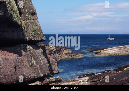 Vue d'un petit bateau de pêche en mer, une pointe près de Culkein sur la péninsule de Stoer, Sutherland, Scotland avec Deep Blue Sea and Sky Banque D'Images