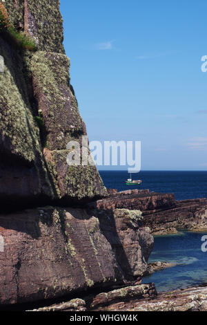 Vue d'un petit bateau de pêche en mer, une pointe près de Culkein sur la péninsule de Stoer, Sutherland, Scotland avec Deep Blue Sea and Sky Banque D'Images