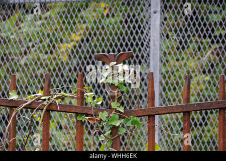 Old rusty forgé autour d'Whitecrook Park avec une voie de chemin de fer moderne clôture de sécurité derrière elle. Tous les points ont été coupées pour éviter les accidents Banque D'Images