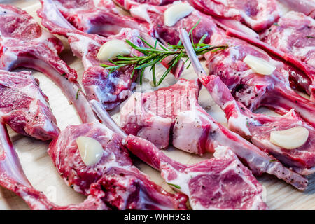 Côtelettes d'agneau cru mariné à l'ail et du romarin frais. La nourriture de la viande biologique. Banque D'Images