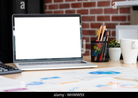 Ordinateur portable avec écran la maquette graphique d'affaires,marché,caculator Coffee cup,pencil box sur 24 au mur de brique à la salle de réunion de bureau moderne.device te Banque D'Images