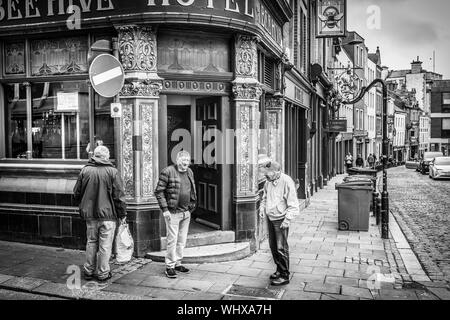 Le jour de match, trois amis chat à l'extérieur de la Ruche Hotel au milieu de Newcastle. Banque D'Images