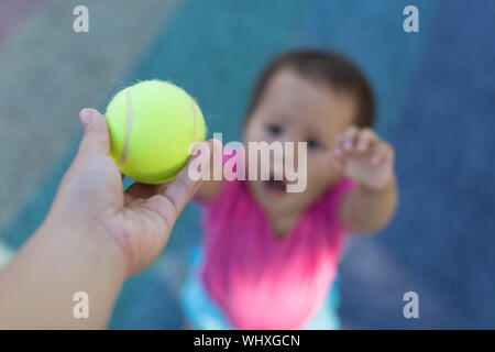 Balle de tennis dans l'accent, la remise à l'enfant Banque D'Images