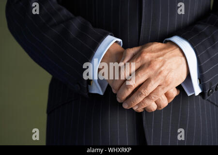 Closeup Portrait of a businessman in suit standing with hands clasped Banque D'Images