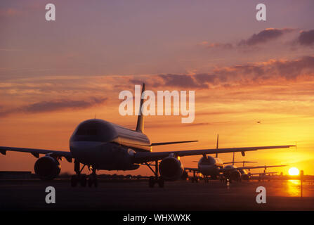 Assis sur des avions Tarmac au coucher du soleil Banque D'Images