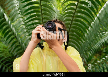 Jeune garçon en manteau de prendre des photos dans la forêt pendant le voyage Banque D'Images