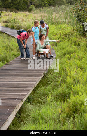 Enseignant montrant quelque chose à des enfants sur l'excursion nature Banque D'Images