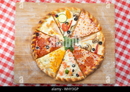 Assortiment de tranches de pizza close-up avec des ingrédients différents décoré avec du basilic, un assortiment de fast food italien traditionnel Banque D'Images