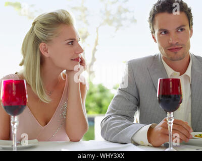 Belle jeune femme admirant man at dinner table Banque D'Images