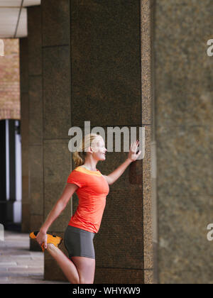 Vue latérale d'une jeune femme qui s'étend contre pilier dans portico Banque D'Images