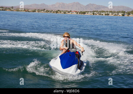 Portrait d'un jeune homme à cheval sur le lac de jetski Banque D'Images