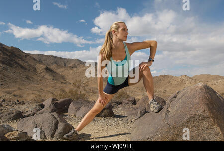 Female jogger stretching en montagne Banque D'Images