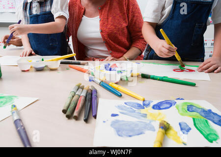 Au milieu des étudiants tout en aidant l'enseignant en classe d'art peinture Banque D'Images