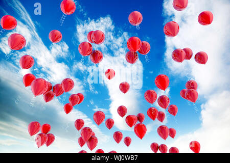 Ballons rouges flottant sur le ciel bleu Banque D'Images