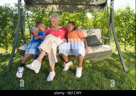 Happy African American woman avec petits-enfants assis sur la balançoire Banque D'Images