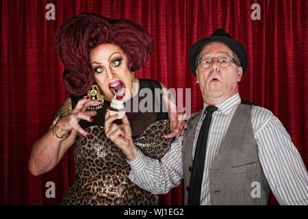 Hungry drag queen et ami holding cupcake Banque D'Images