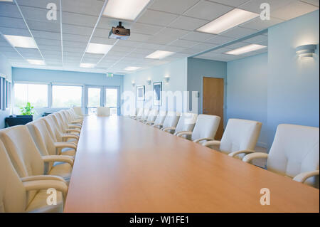 Chaises vides autour de table dans une salle de conférence Banque D'Images