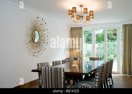 Avis de lustre allumé sur la table de salle à manger avec art décoration sur le mur à la maison Banque D'Images