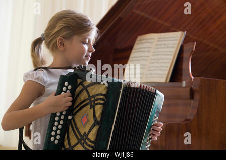 Vue latérale d'une jeune fille à jouer de l'accordéon Banque D'Images