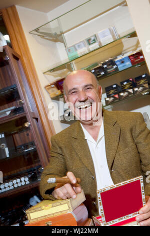 Portrait of young man smoking cigar en magasin de tabac Banque D'Images