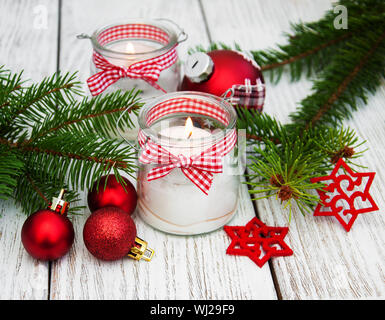 Décorations de Noël des bougies dans des pots de verre avec un sapin sur table en bois ancien Banque D'Images