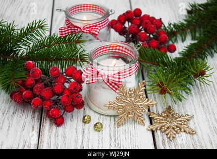 Décorations de Noël des bougies dans des pots de verre avec un sapin sur table en bois ancien Banque D'Images