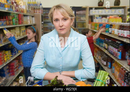 Portrait d'une femme avec son fils et sa fille shopping in supermarket Banque D'Images