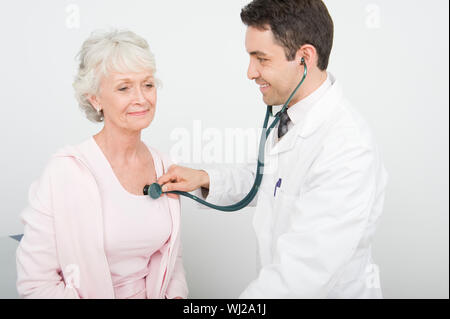 Une mature homme médecin contrôle le rythme cardiaque du patient en utilisant stethoscope Banque D'Images