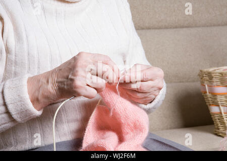 Portrait of senior woman knitting at home Banque D'Images