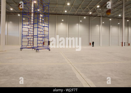 Cadre d'empilage de mobiliers en entrepôt vide avec man in background Banque D'Images