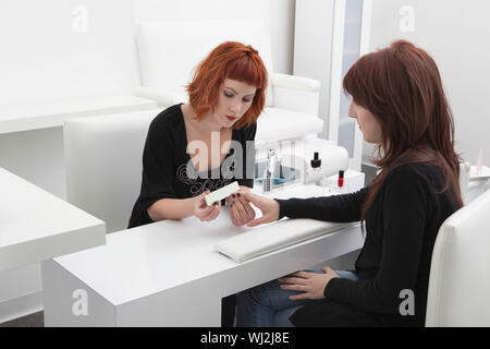 Jeune femme donnant à manucure female customer in salon de coiffure Banque D'Images