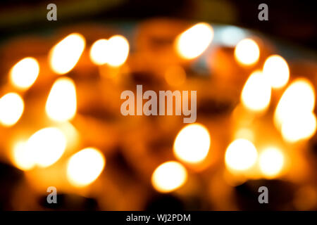 Gros plans flous, à l'allumage de diyas à la main ou d'une bougie pour le festival hindou de Diwali. Ces pots colorés earthern tenir l'huile et un cotto Banque D'Images